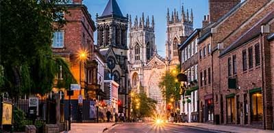 Road leading to York Cathedral, with buildings and shops lining streets