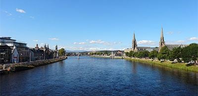 Calm waters of River Ness with banks surrounded by buildings and trees