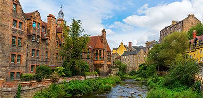 the calm waters of Leith water lined with brick houses and trees 