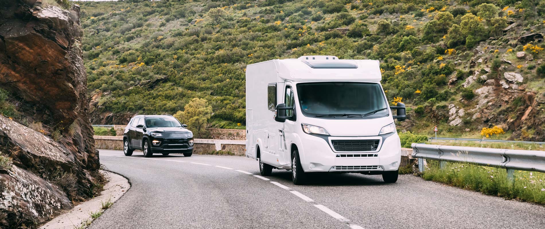 Hired motorhome driving on main road in country valley 