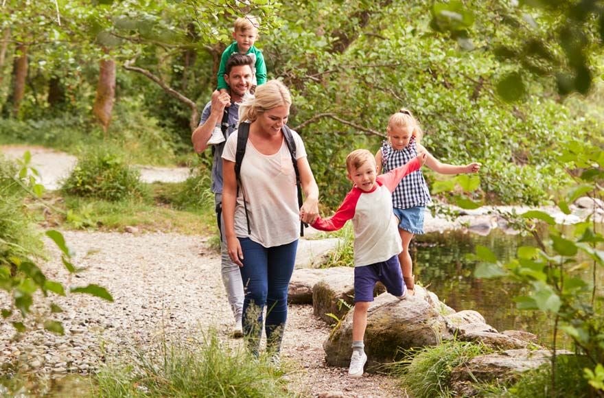 Family of five walking through the woods