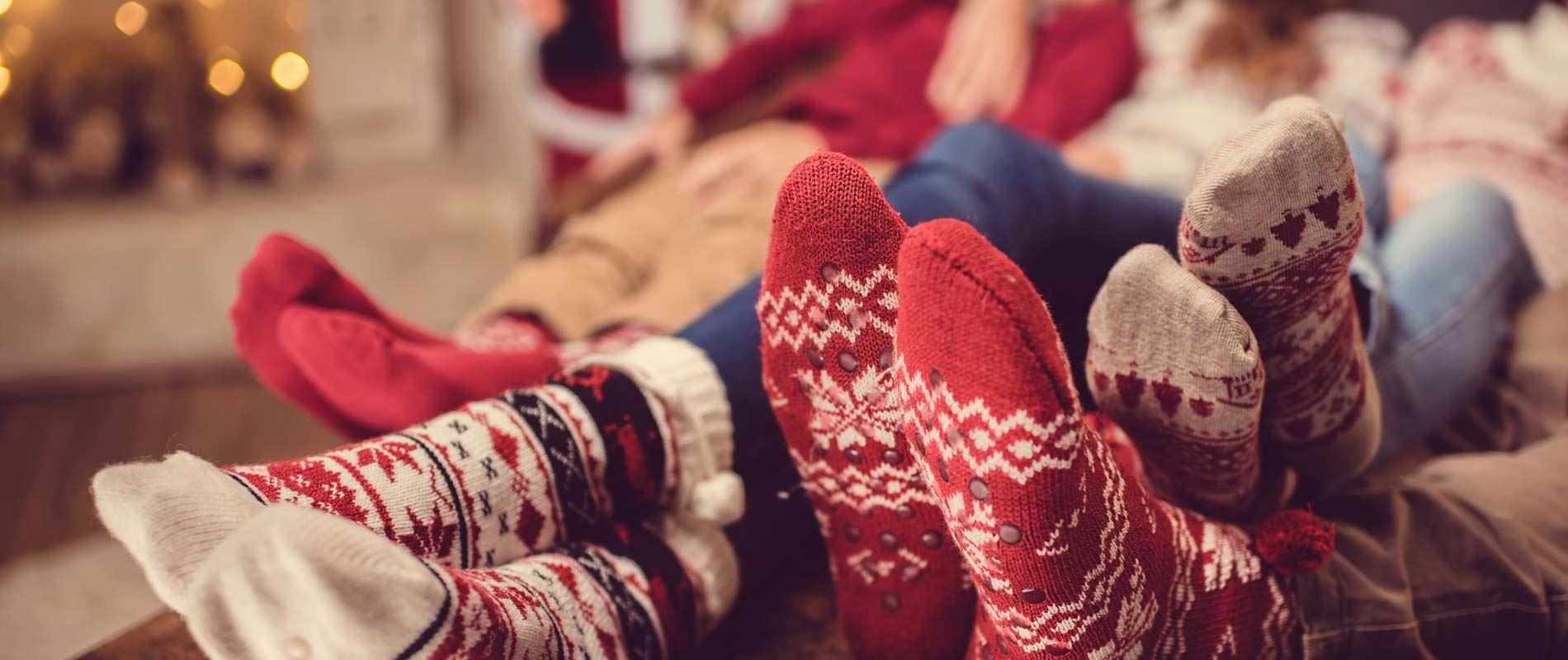 a group of 3 people's feet wearing red and white festive socks in fair lsle print 