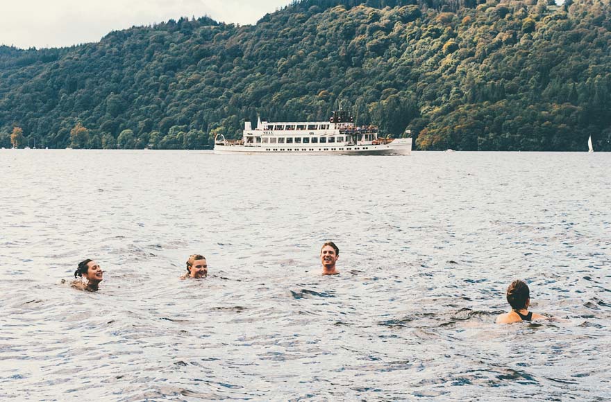 Group of four friends swimming in Lake Windermere, Lake District 