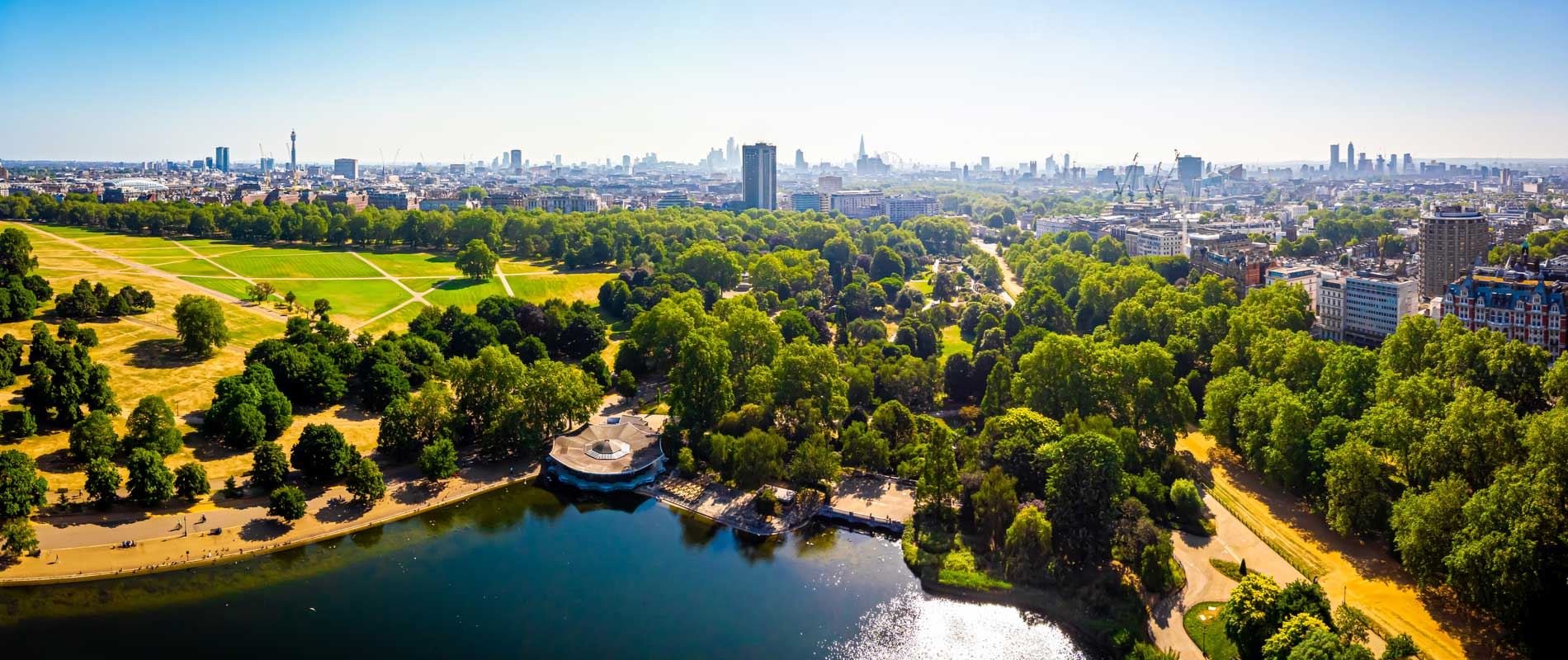 An ariel view of Hyde park, London against a skyline of building 