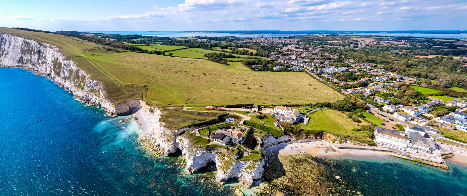 An ariel view of the Isle of Wight showing the impressive chalky coastline and bright blue sea waters 