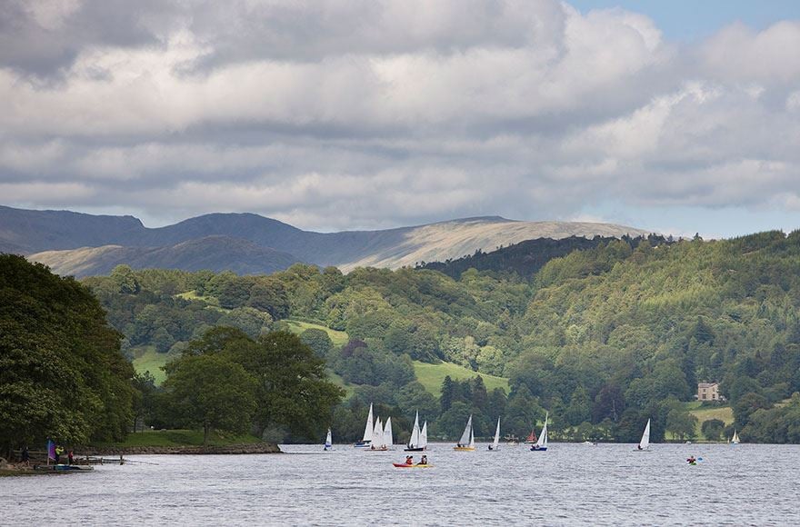 Sail boats crusing on Consiton water with a backdrop of forest  and rolling hills