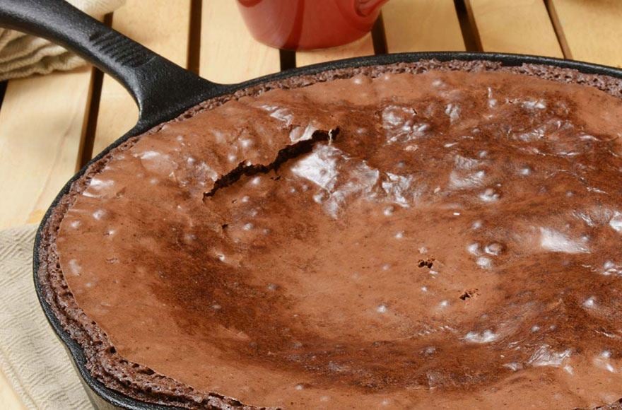 A cast irol skillet filled with delicious brownie with a flakey top