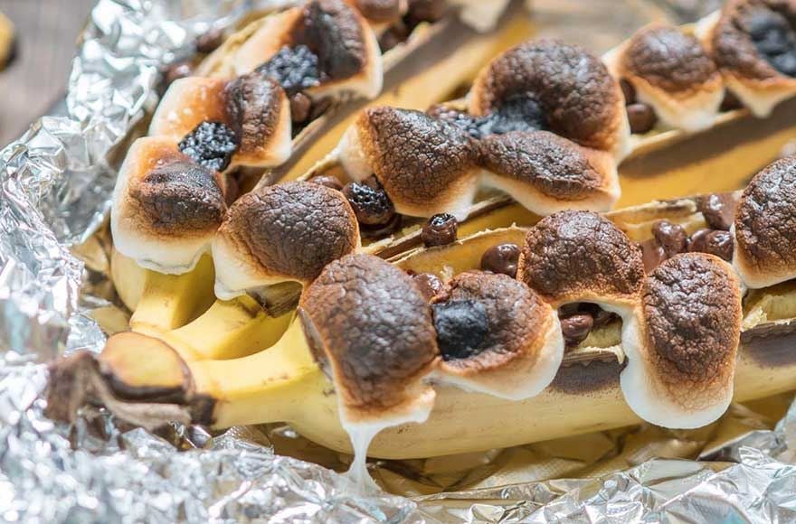 bananas cooking in tin foil ropped with marshmellows and chocolate 