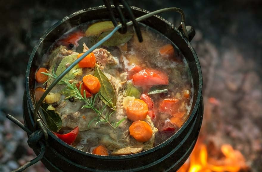 A stew with carrots and herbs in a pot on the stove