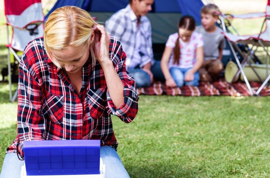 A woman in a checkered shirt looks through a cool box