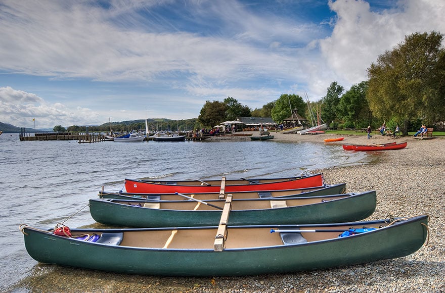 three canoes lined up on a pebble shore on Coniston Water