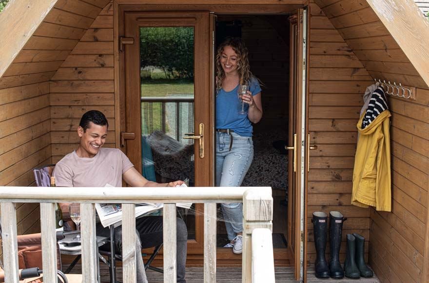 Couple in the porch of a camping pod at the Experience Freedom Brighton campsite