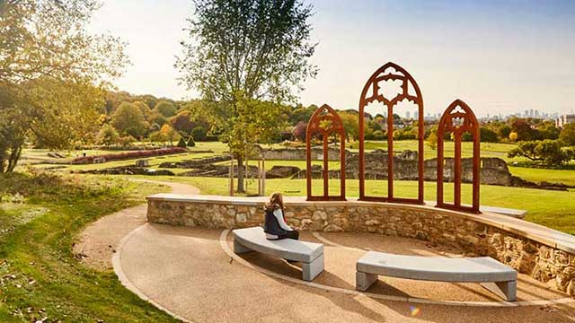 A woman enjoys the view of London through three arched window frames at Abbey Wood Club Campsite