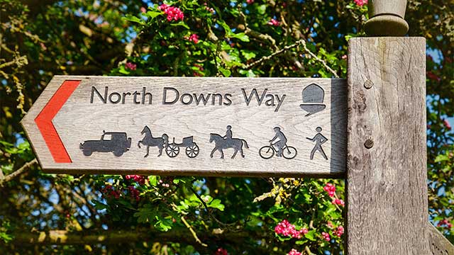 Sign showing the routes along the North Downs Way, near Alderstead Heath Club Campsite