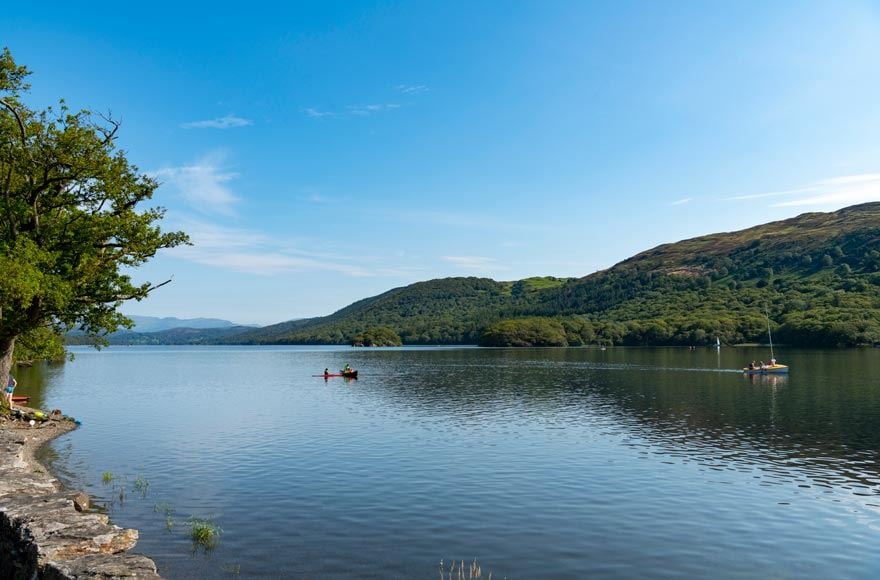 personing canoeing in the distance on a vast lake near coniston 