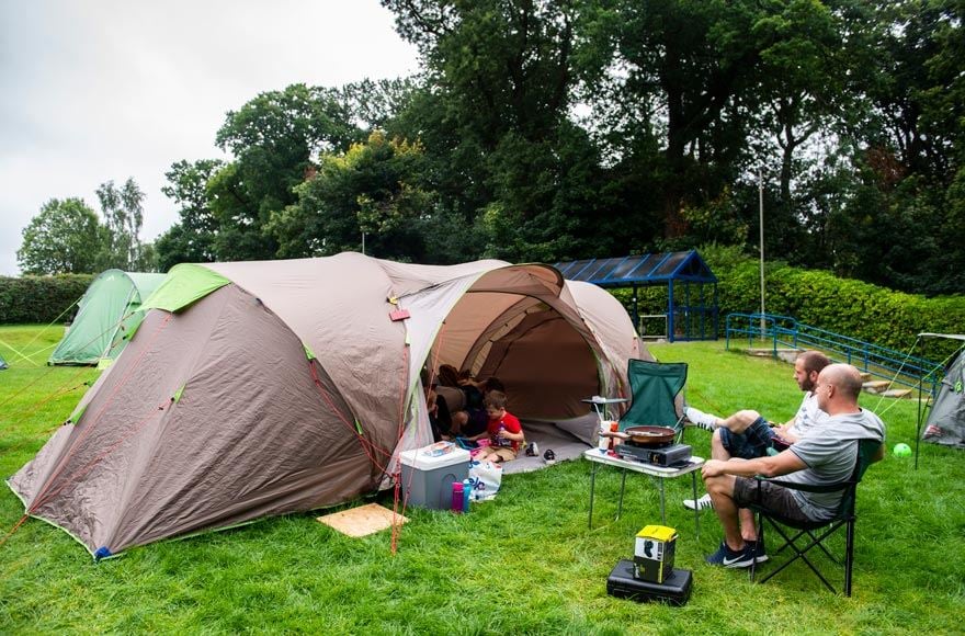 Tent camping people relaxing and cooking