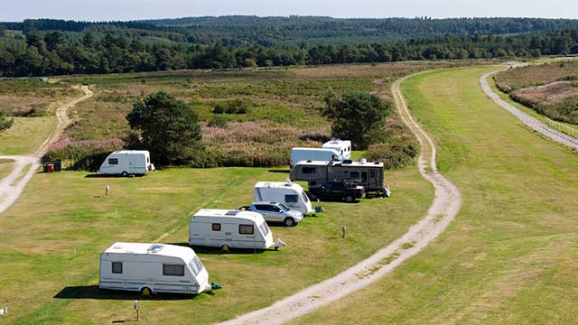 Caravans line up along the grass at Exeter Racecourse Cub Campsite