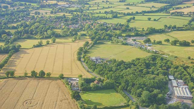 Aerial view over green fields near Gatwick Club Campsite