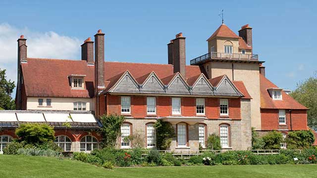 The sun shines on Arts and Crafts Standen House, near Gatwick Club Campsite