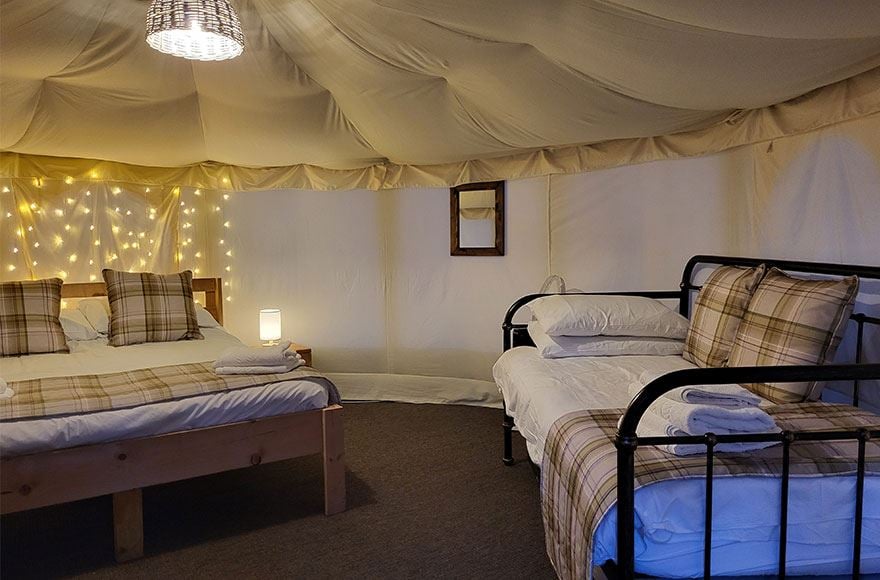 Interior view of a classic yurt showing a bed and a sofa bed 