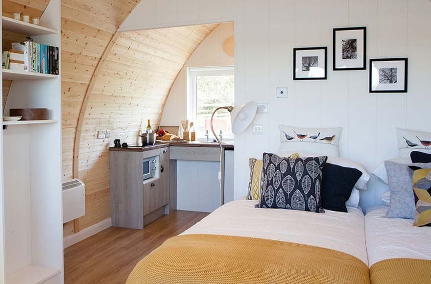 Interior of glamping pod showcasing a bed and kitchen