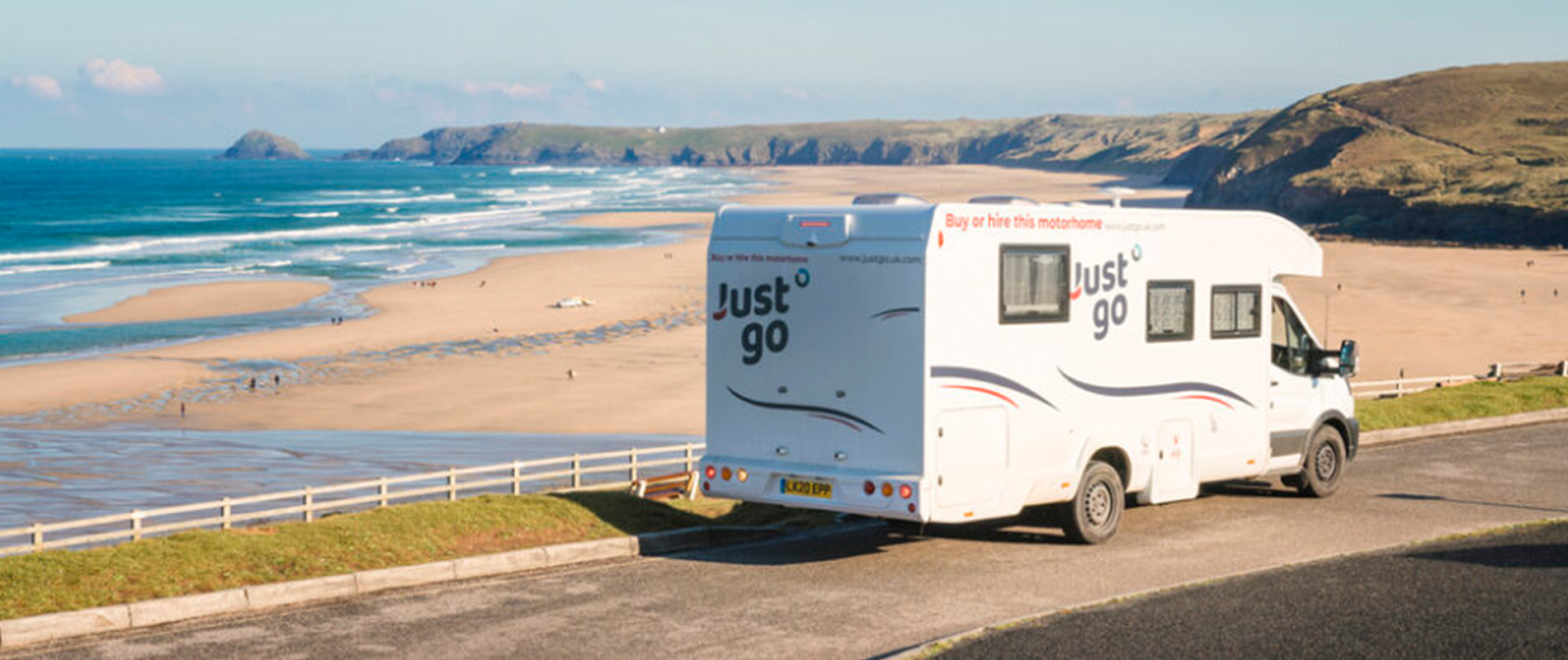 Just go motorhome with sandy beach and blue see in the background