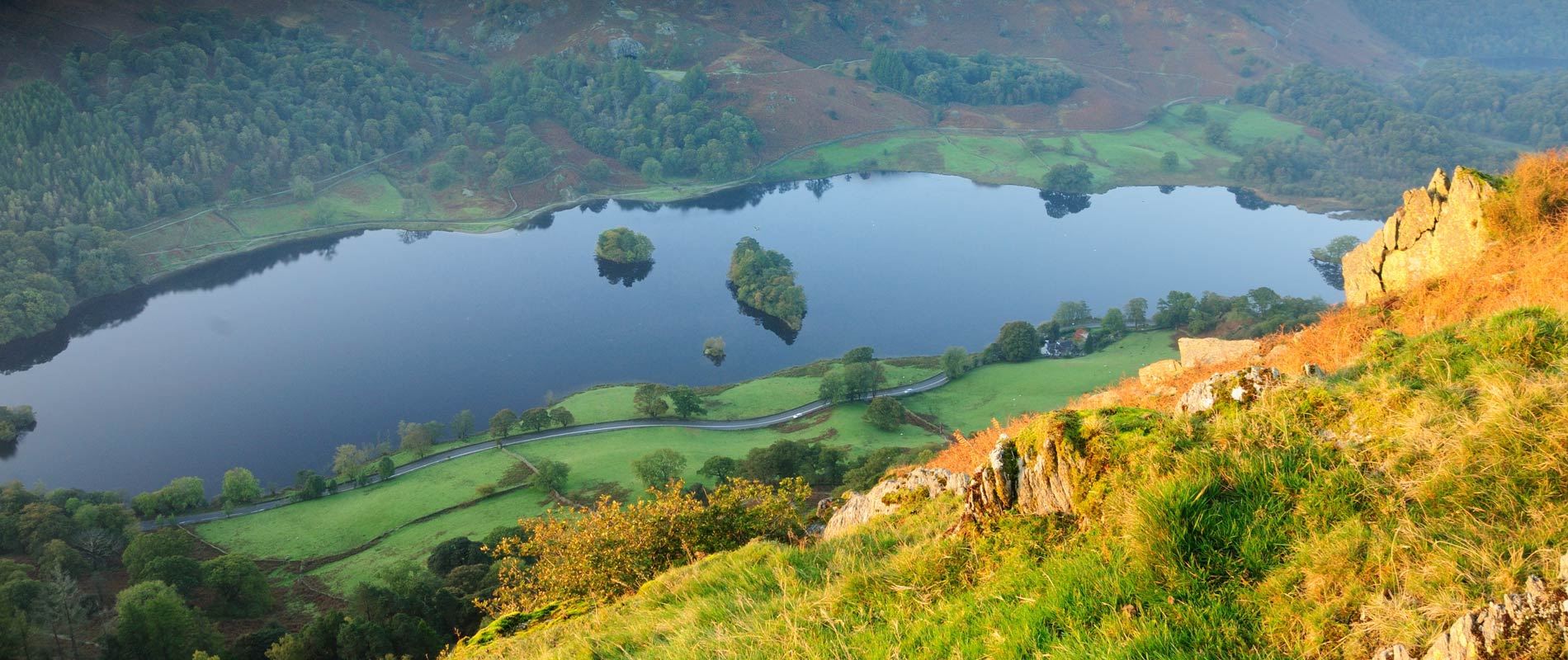 Aerial view showing the blue water across Coniston Water surrounded by trees