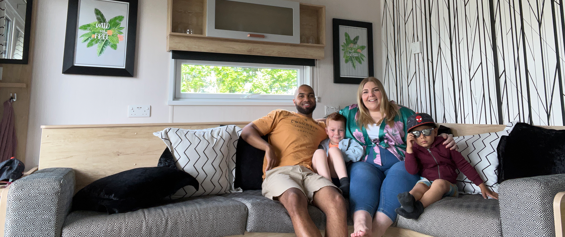 family of four relaxing on the sofa of a glamping cabin