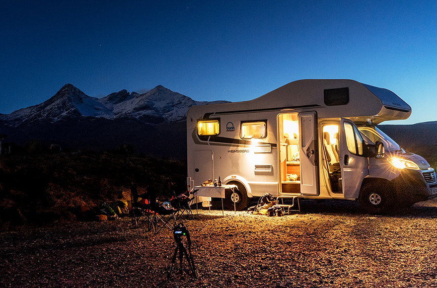 motorhome parked up at night with mountains in the background 