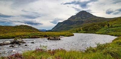 Mountain peak of Ben Hope surrounded by a lake 