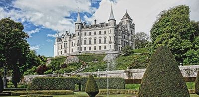 Dunrobin Castle on a  hill surrounded by trees