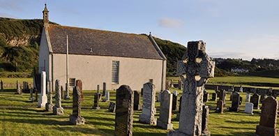 Strathnaver Museum surrounded  by graves bathed in sunlight  