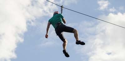 man hanging from a zip line