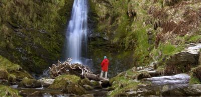 Onlooker admiring Pistyll Rhaeadr waterfall in Wales